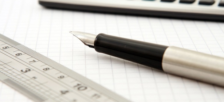A pen on a paper next to a ruler.