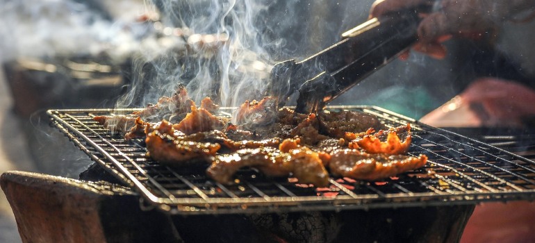 A person grilling meat on a barbecue.