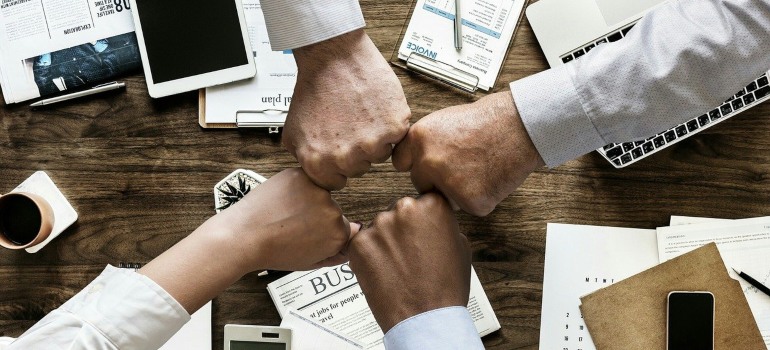 A group of people bumping fists after installing your artificial turf in Nevada.