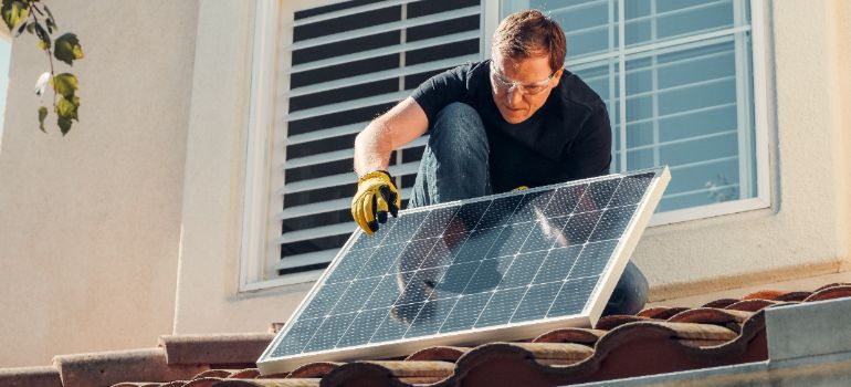 hiring professional roof cleaners handling solar panels before pressure washing