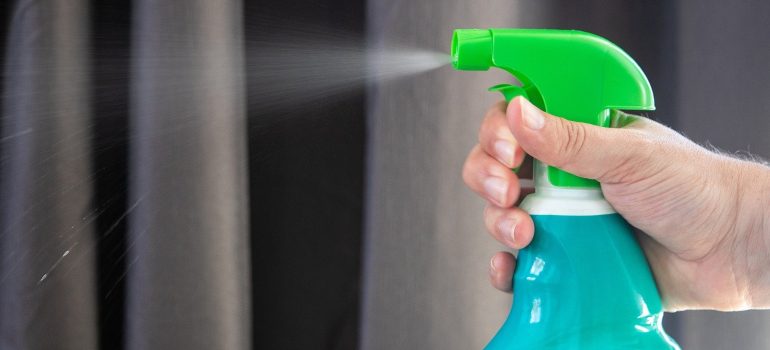A person holding a spray bottle.