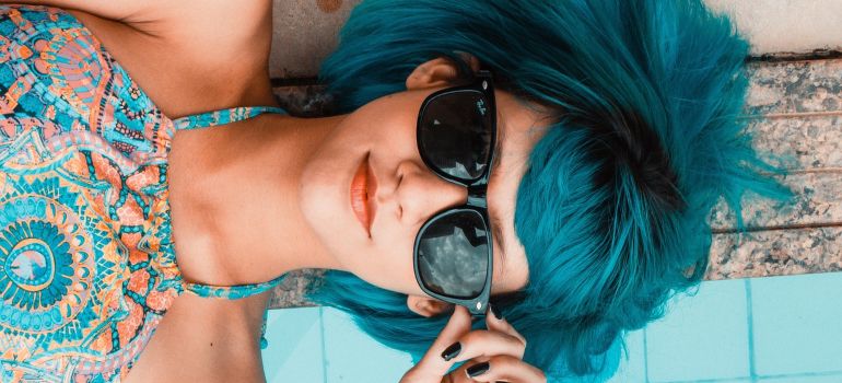 A girl lying on the ground and wearing sunglasses.