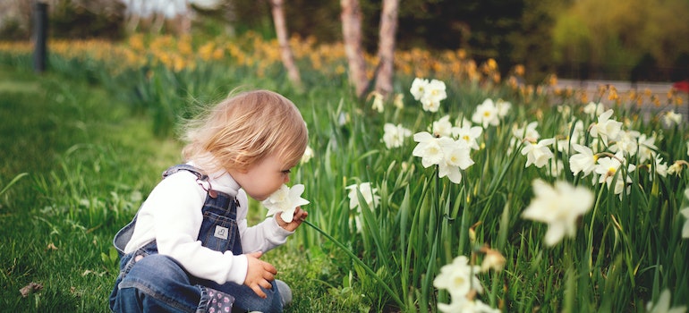 kid sitting on natural grass