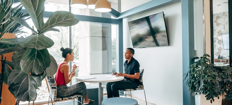 Two people talking in the small office