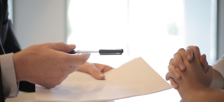 A person giving contract to sign to another person